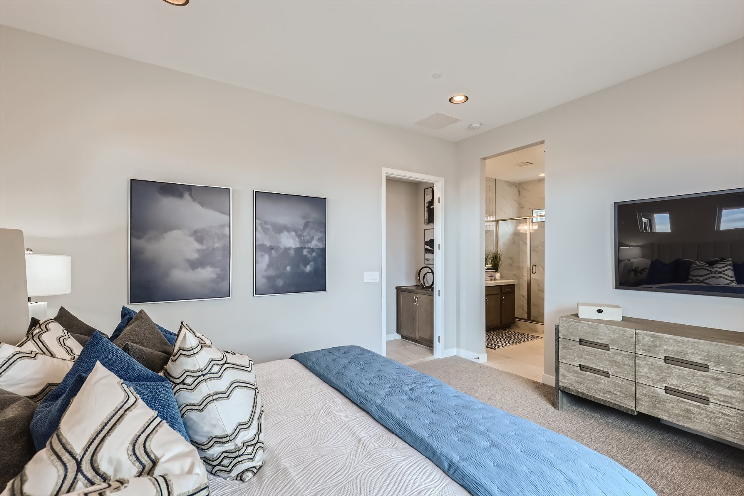 A bedroom with a bed and a mirror.