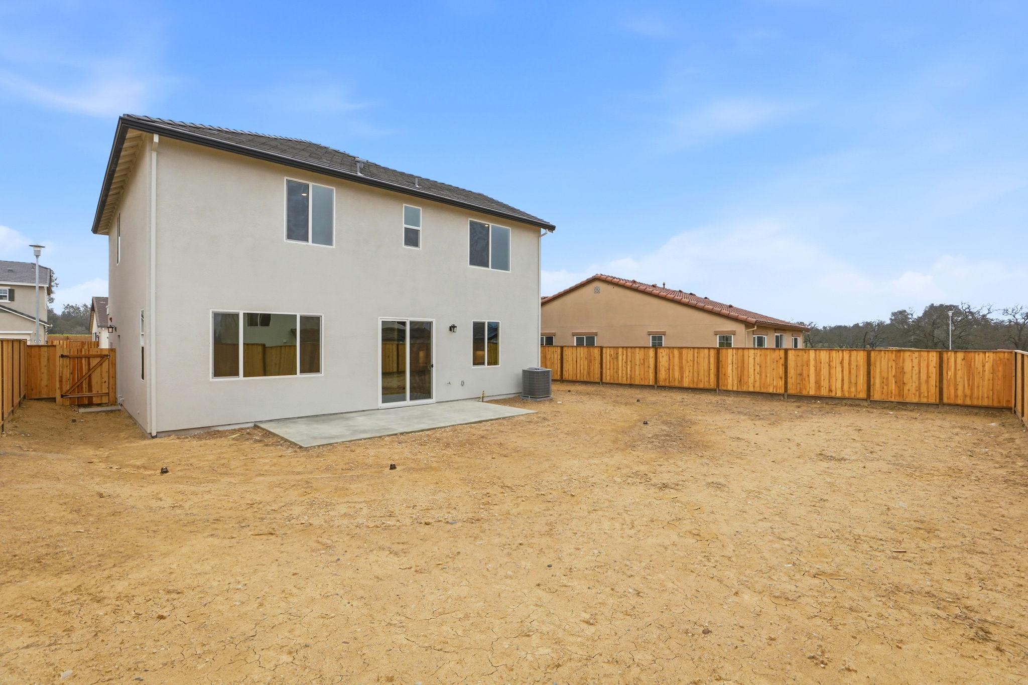 A white house in a dirt field.