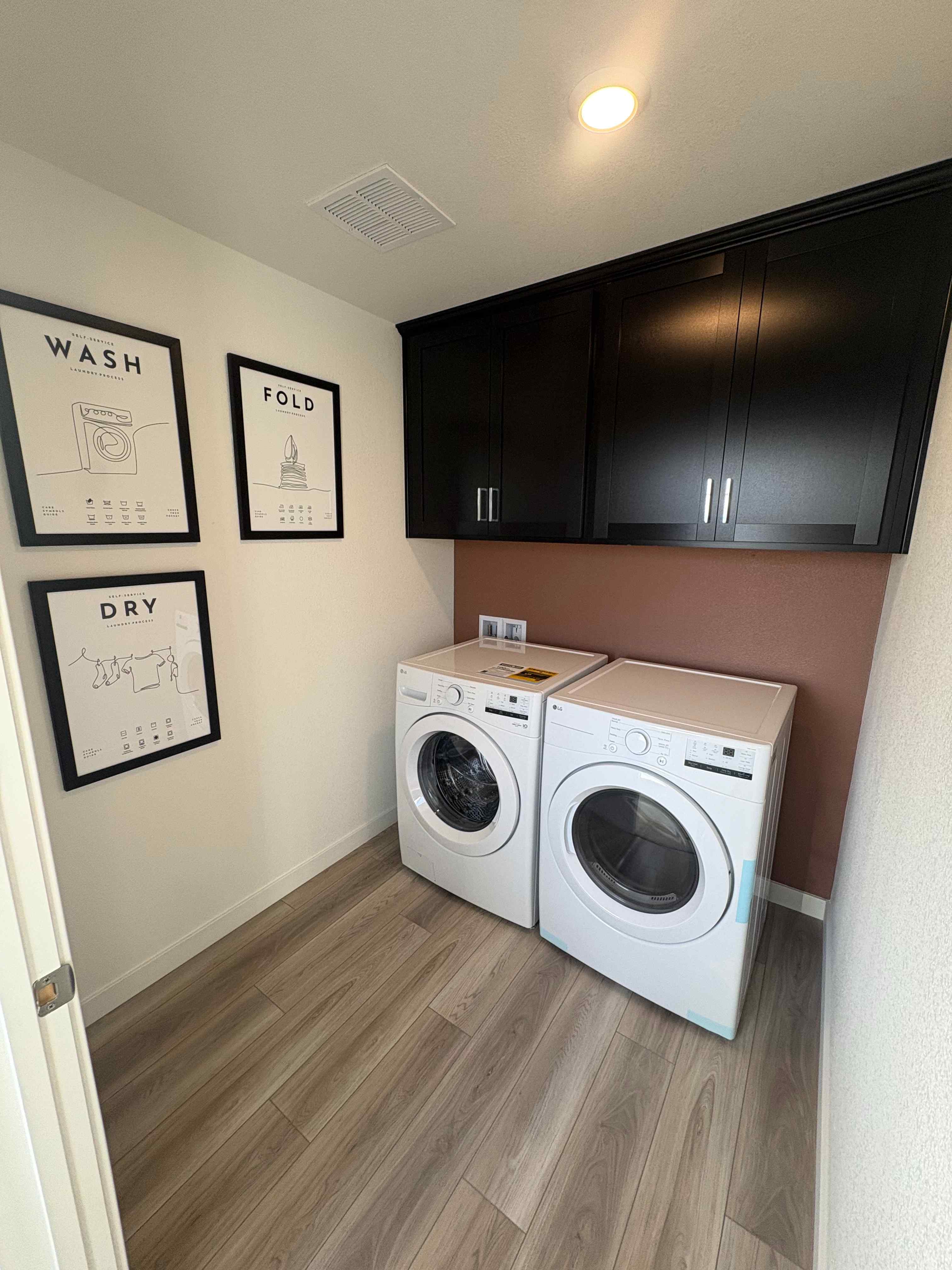 A room with a washing machine and a dryer.