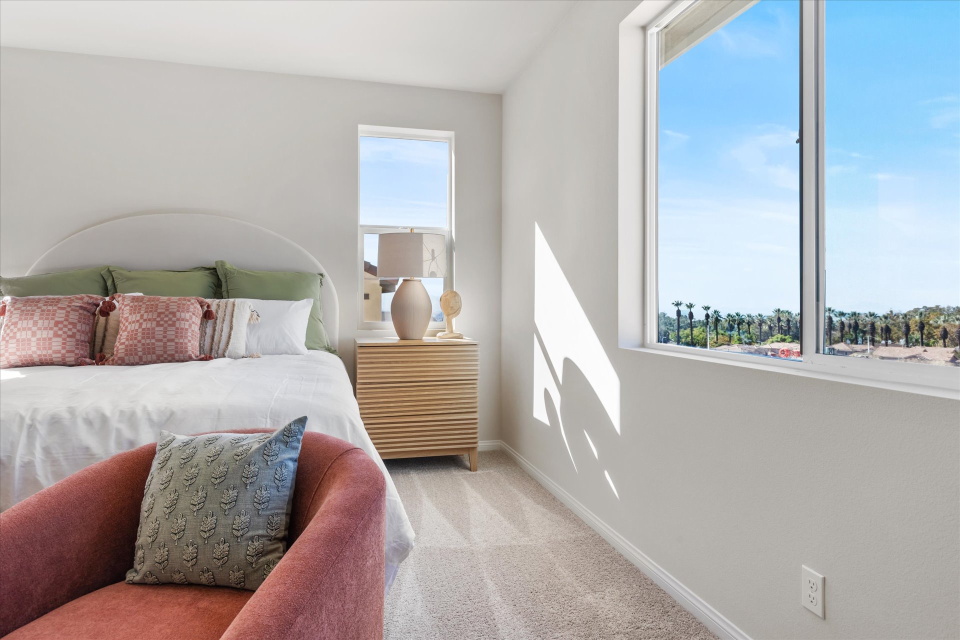 A bedroom with a large window.