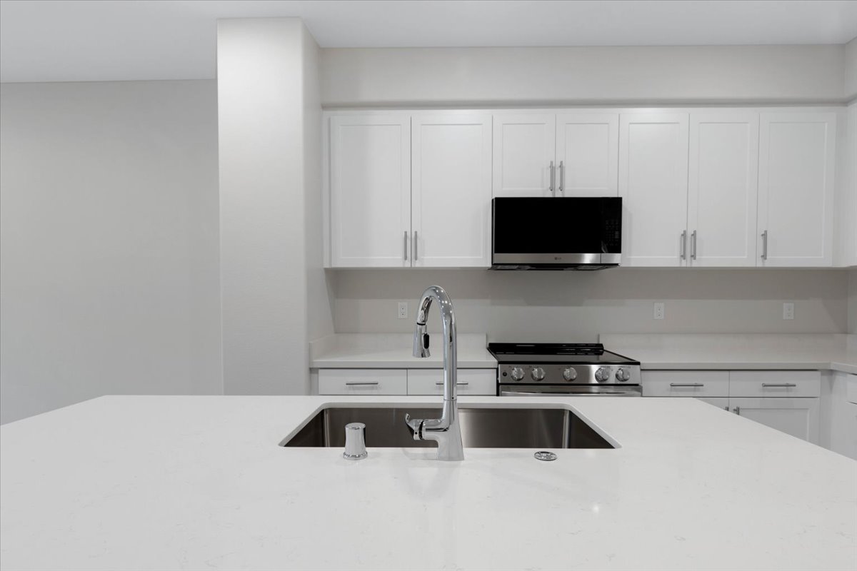 A kitchen with white cabinets.