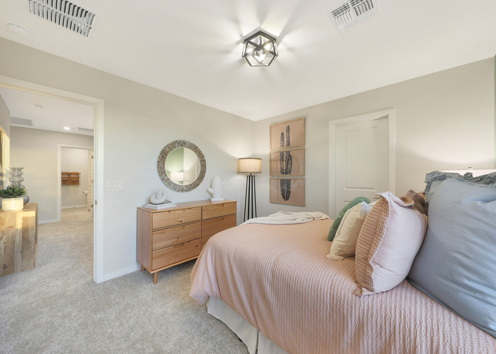 A bedroom with a bed and a mirror.