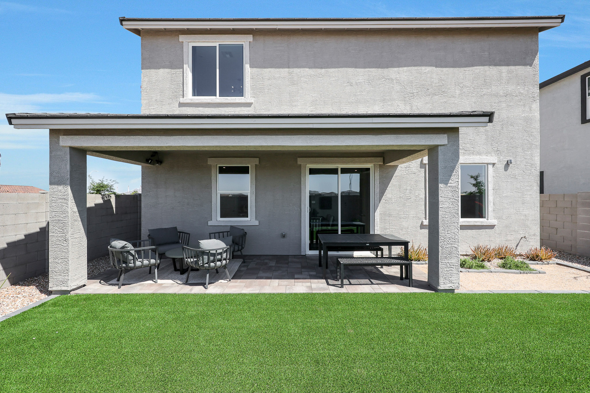 A house with a lawn and chairs.