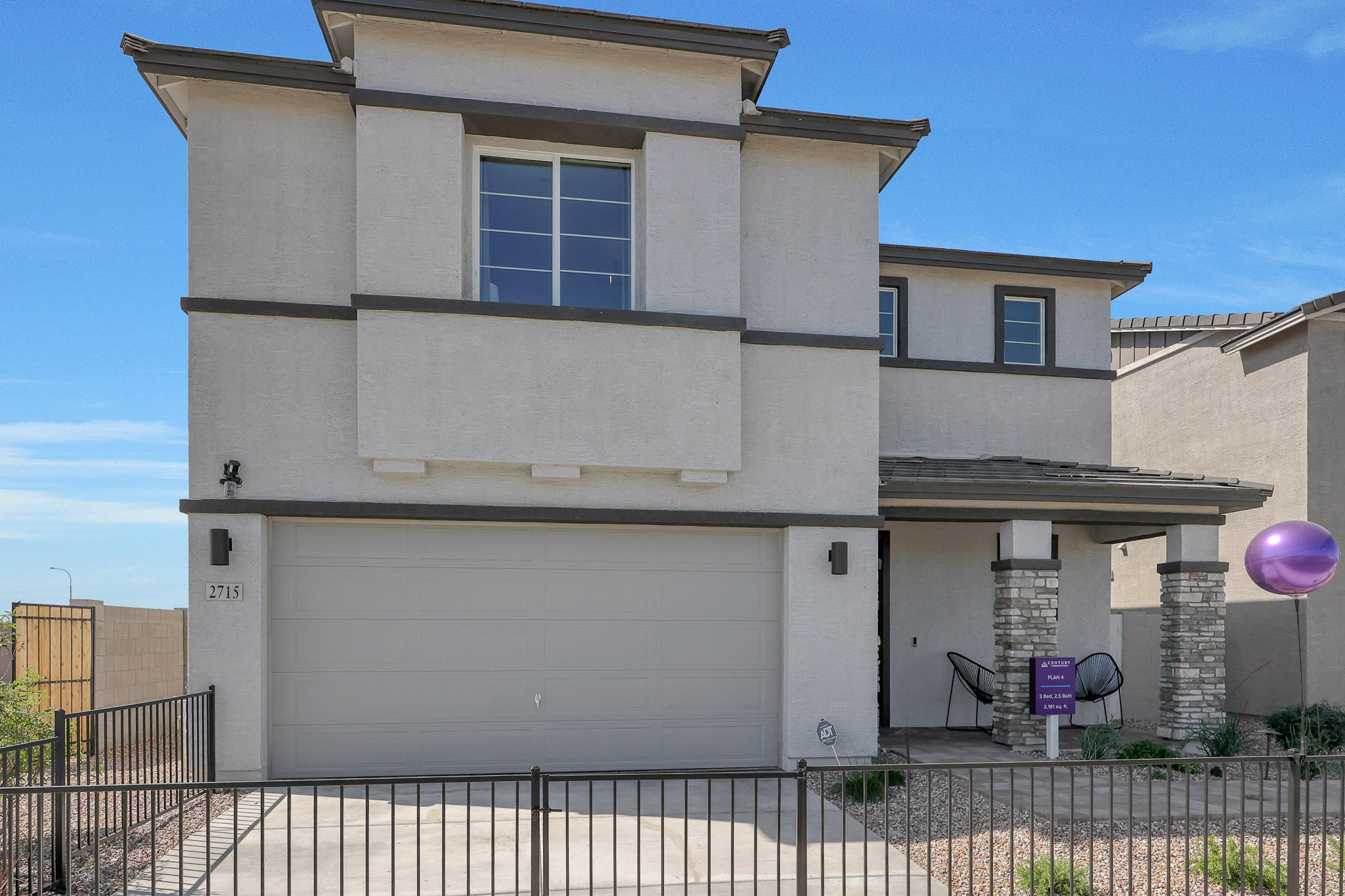 A white building with a black fence.