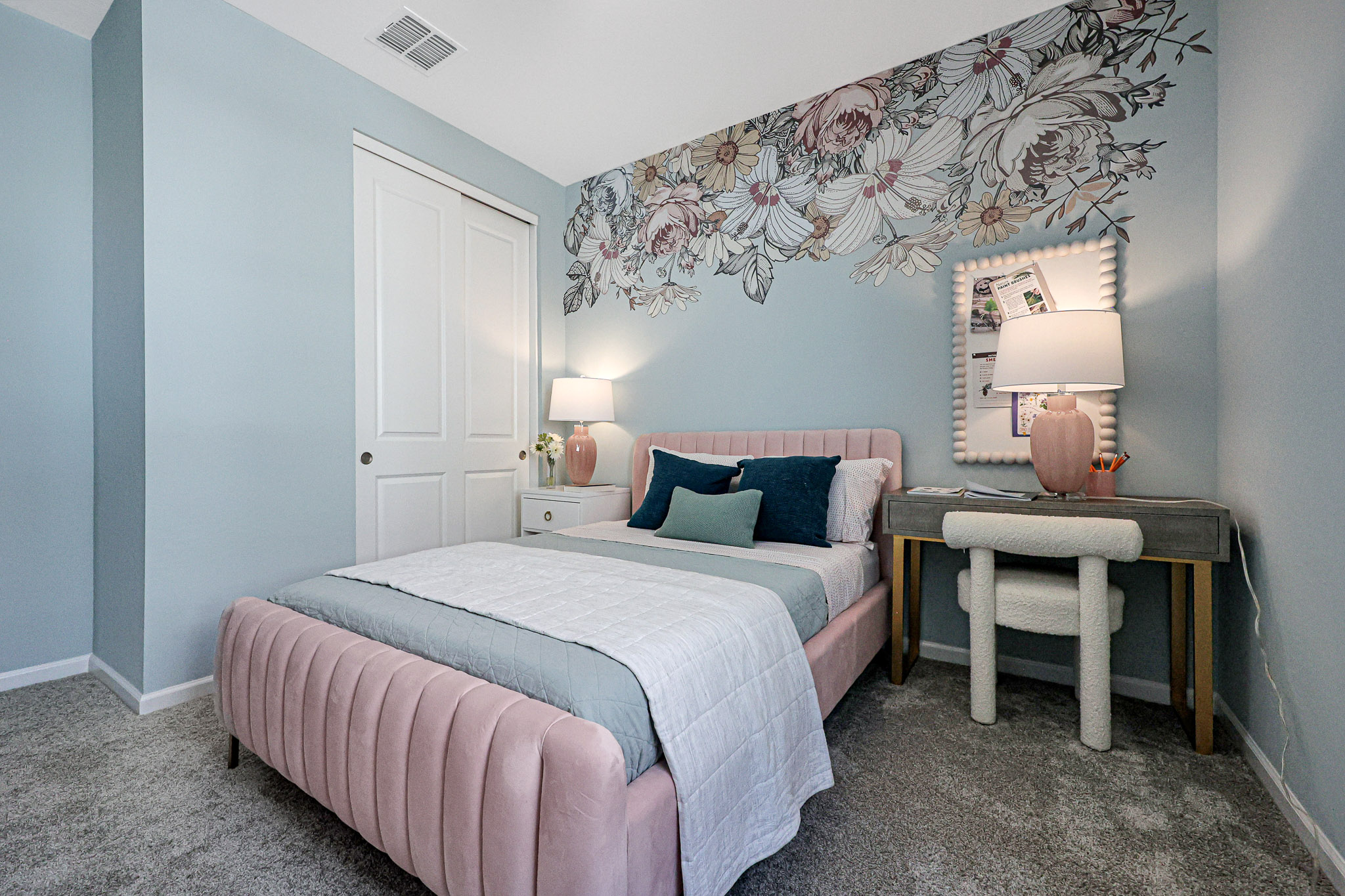 A bedroom with a bed and a desk.