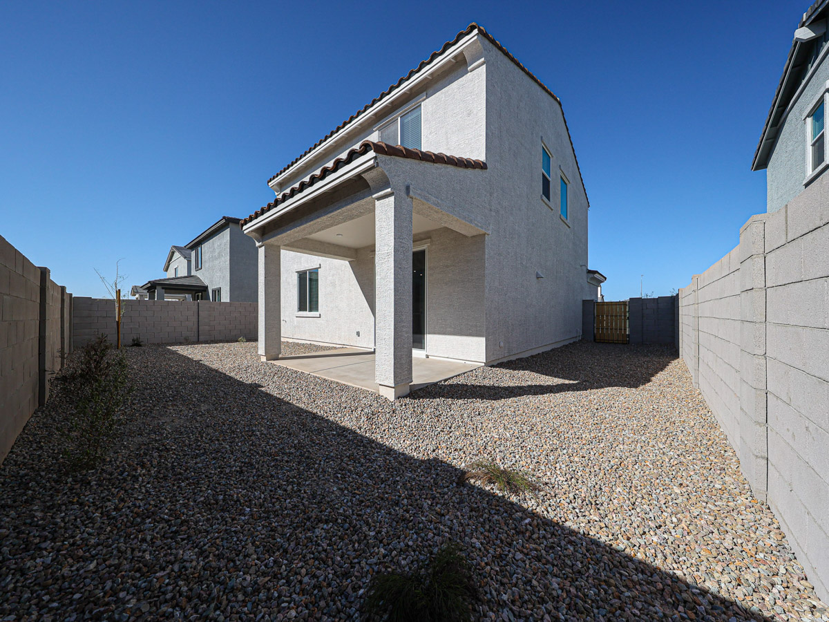 A white house with a stone driveway.