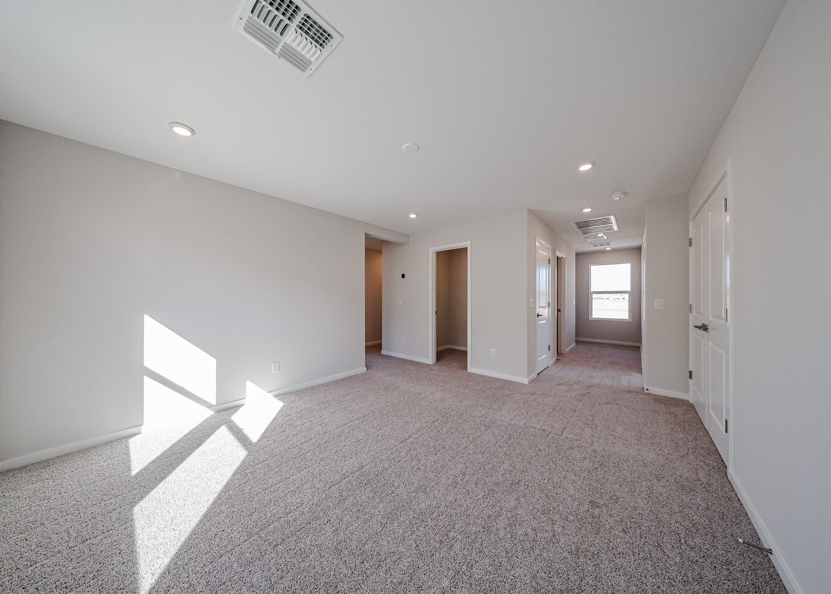 A long hallway with white doors.