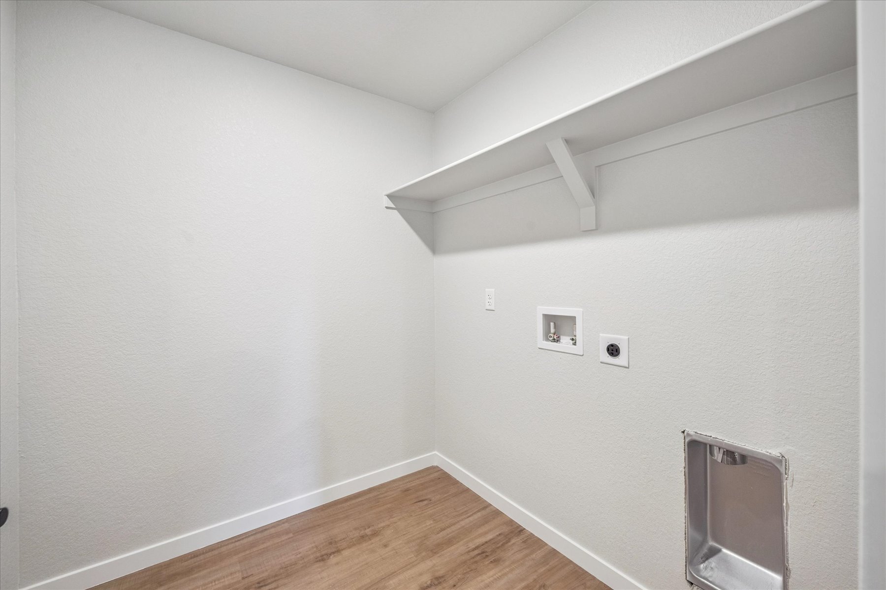A room with a wood floor and white walls.