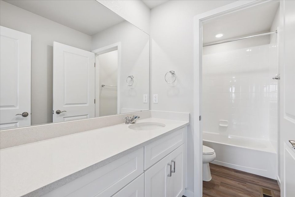 A bathroom with a tub sink and toilet.