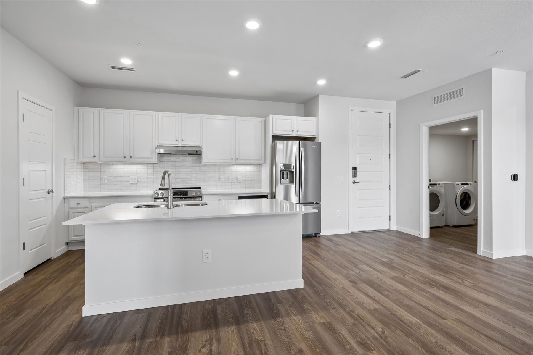 A kitchen with white cabinets.
