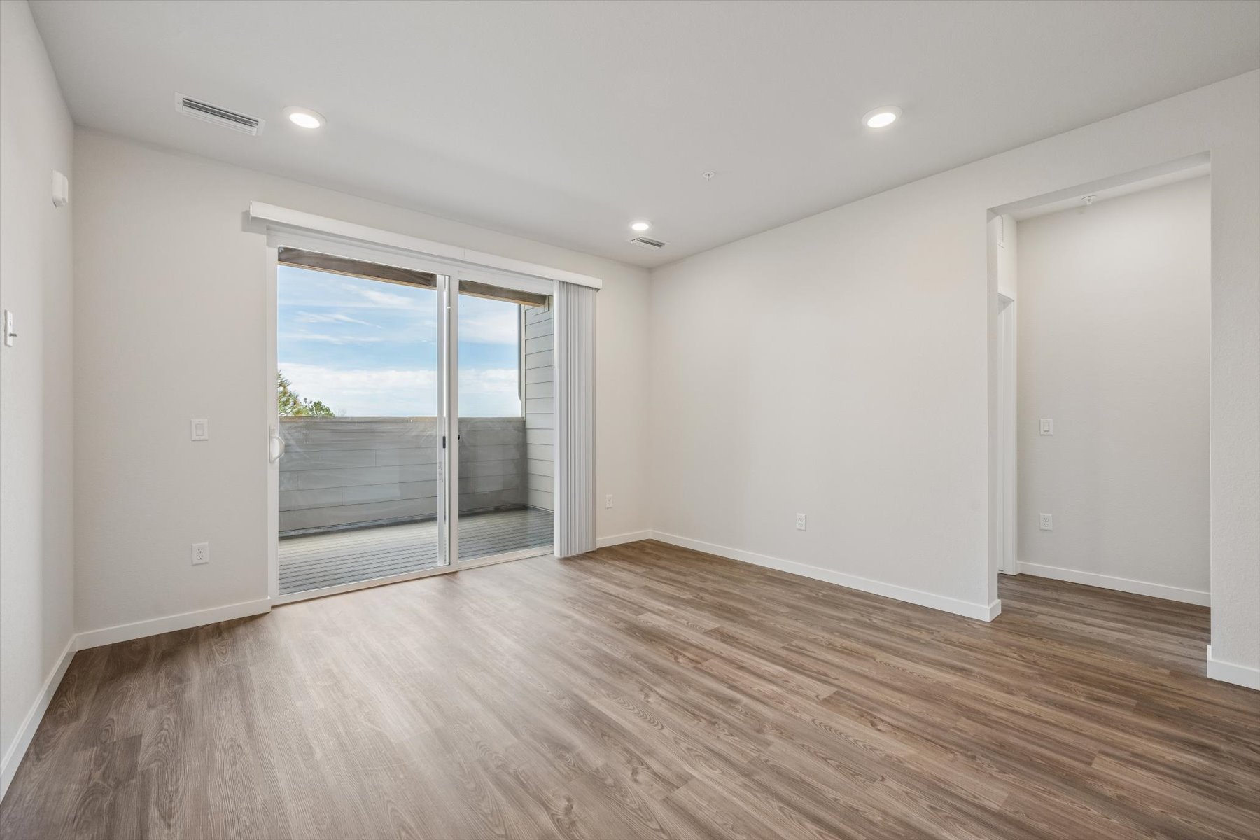 A room with a wood floor and a wood floor with a large window.