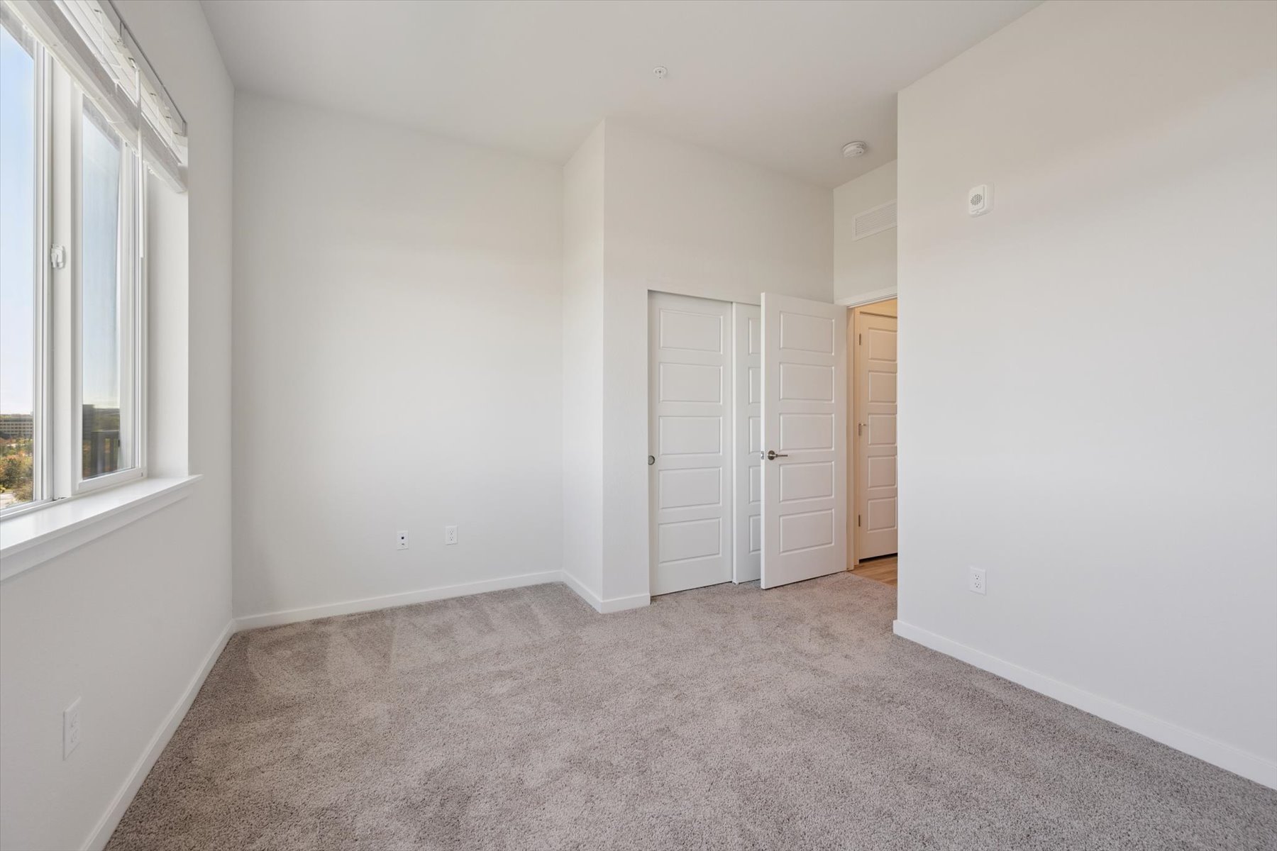 A room with white walls and a carpet.