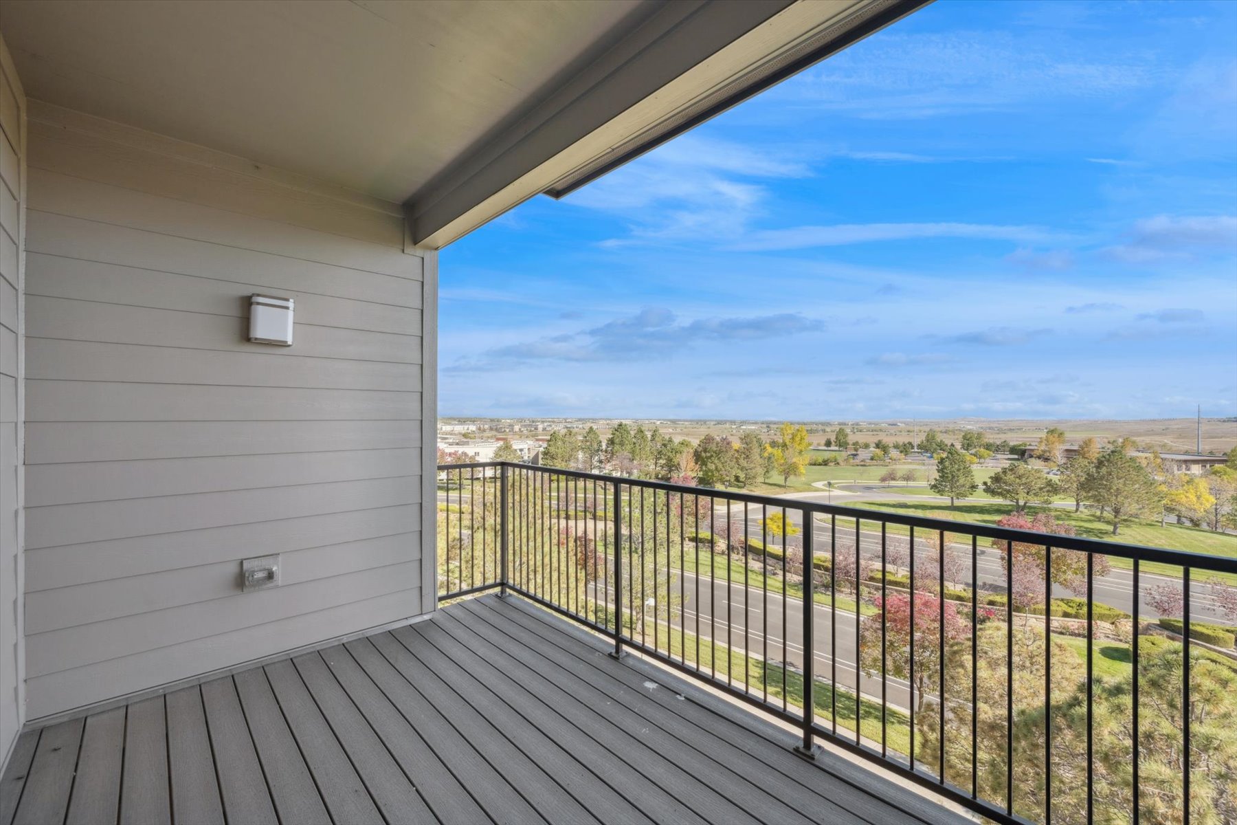 A deck with a view of trees and a field.
