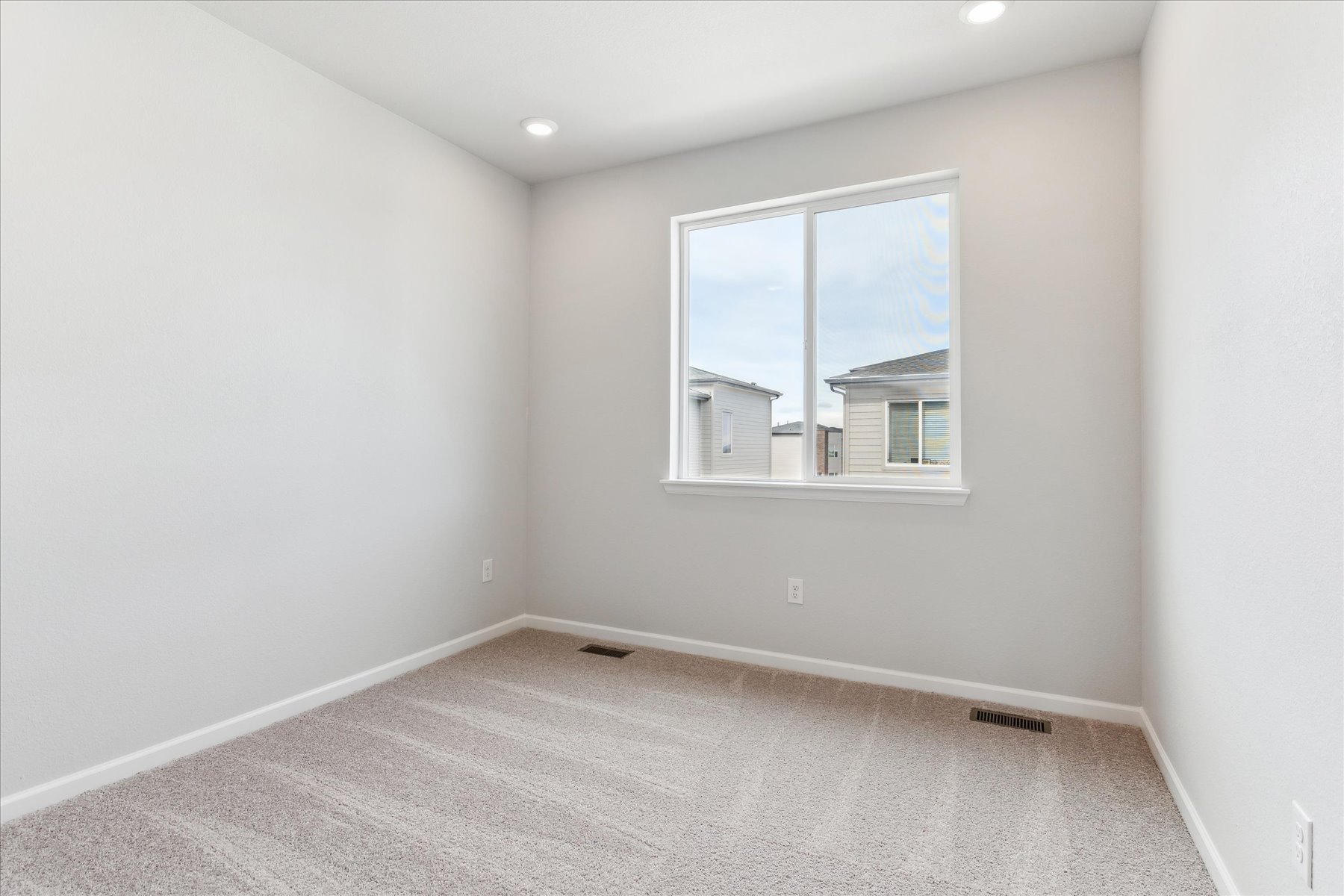 A room with a window and a carpet.