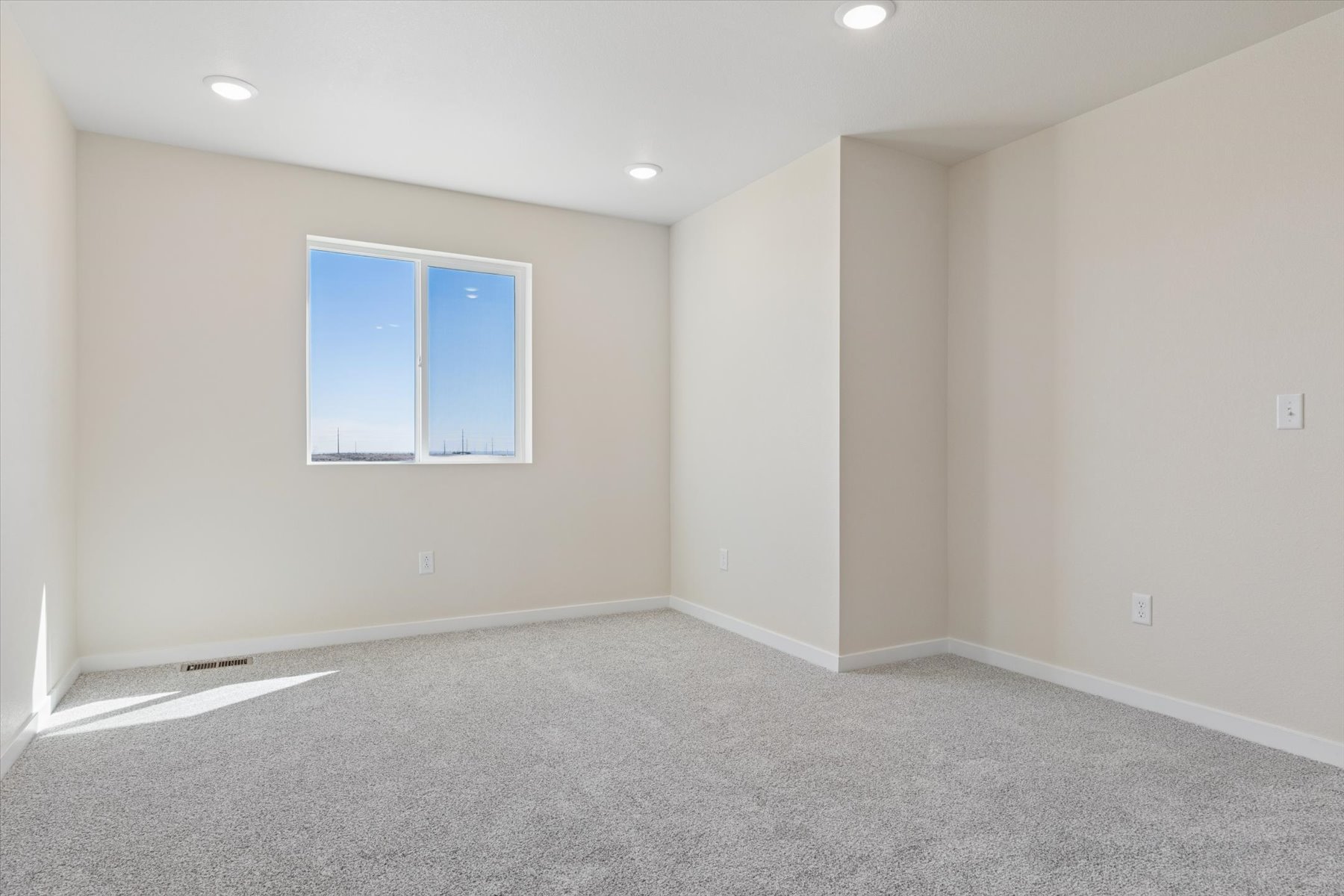 A room with a window and a carpet.