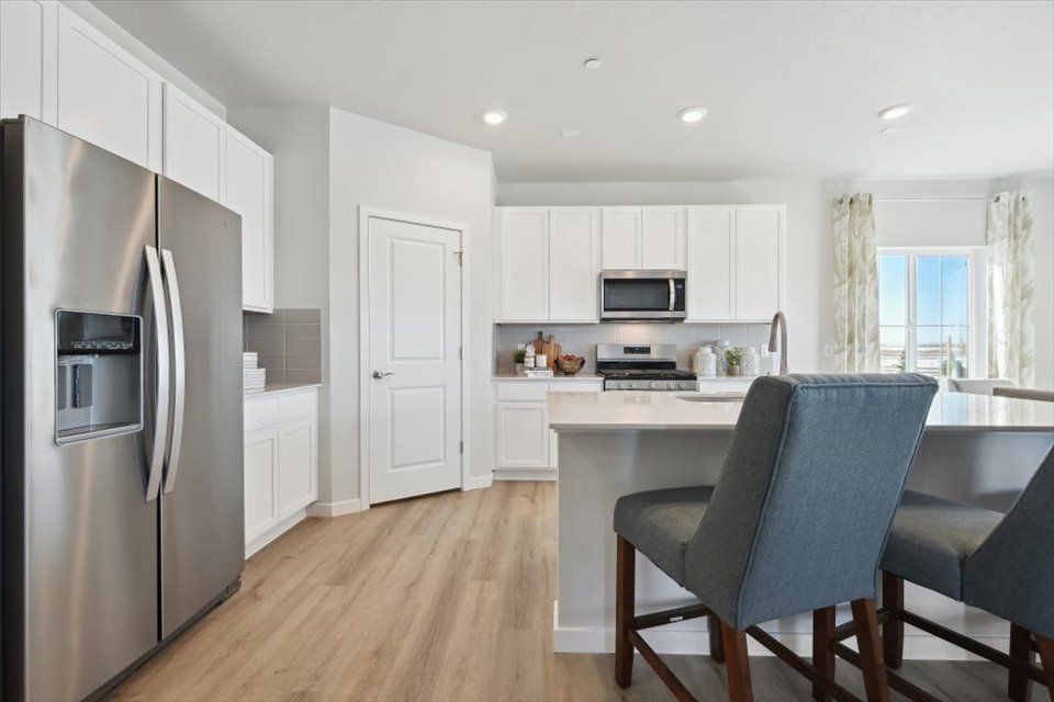 A kitchen with white cabinets.