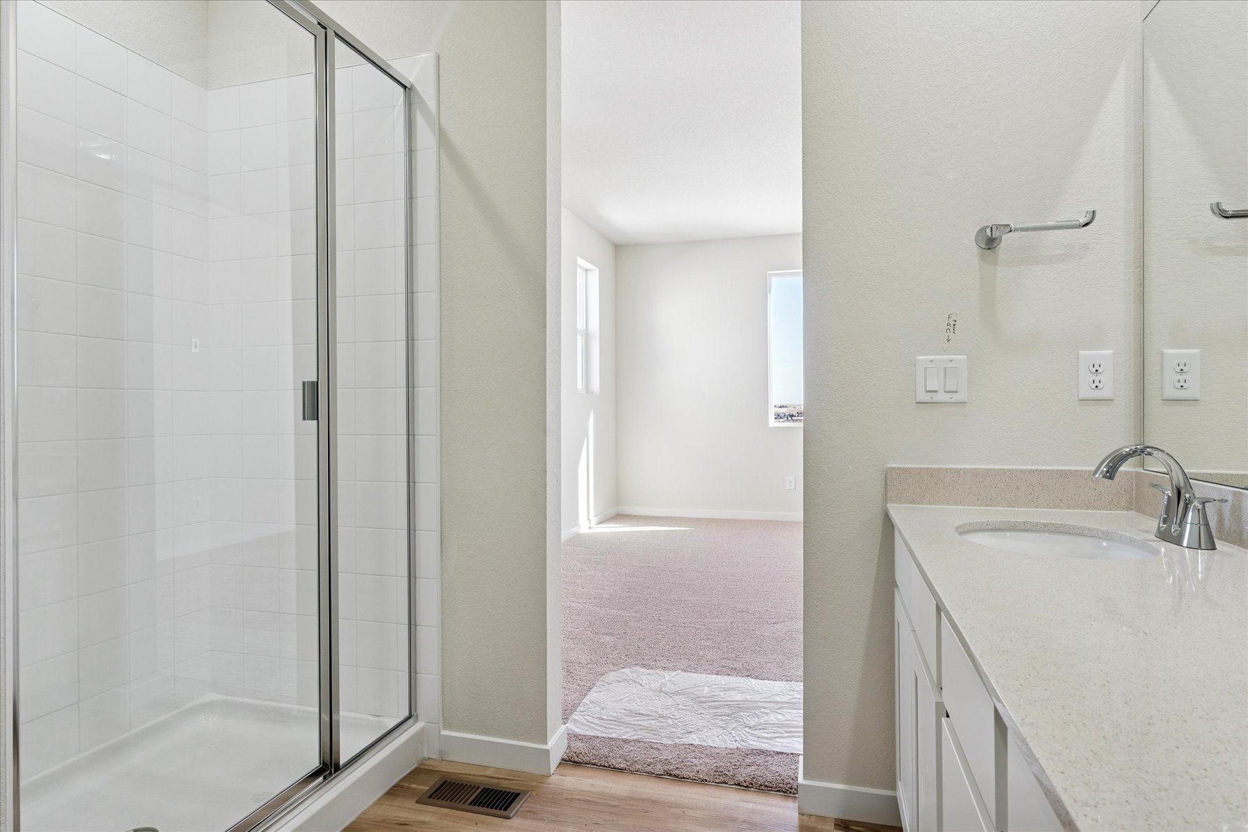A bathroom with a shower unit and sink.