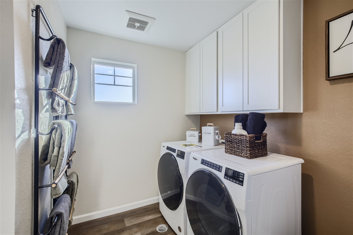 A laundry room with white cabinets.