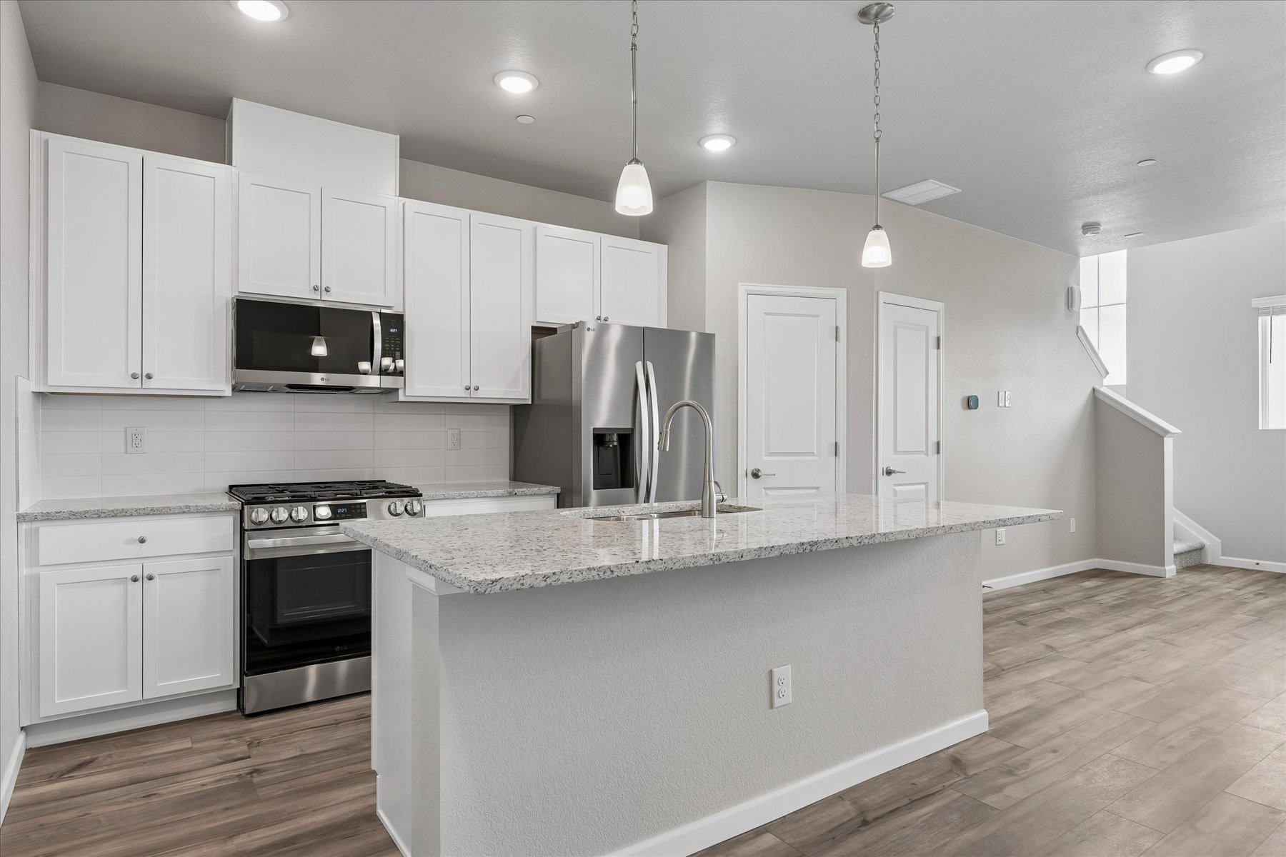 A kitchen with white cabinets.