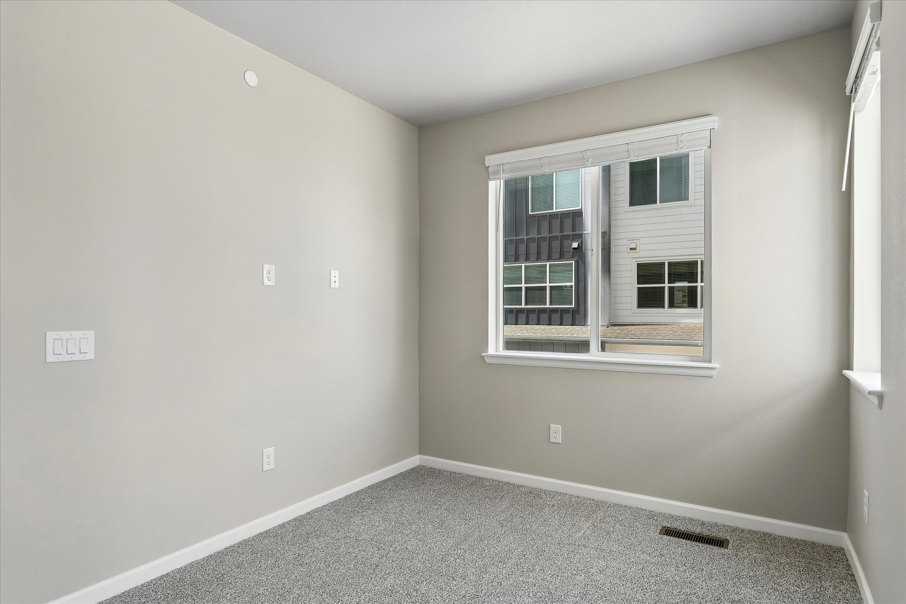 A room with a window and a rug in it.