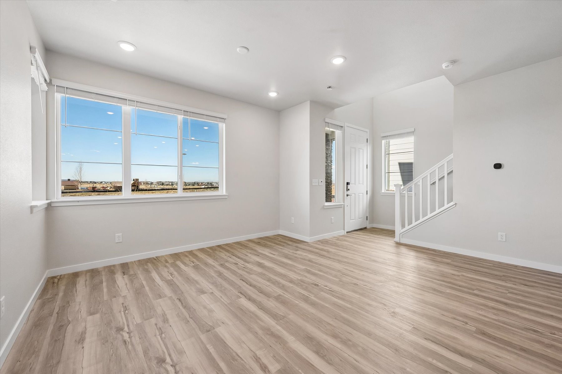 A room with a wood floor and a wood floor with a window.