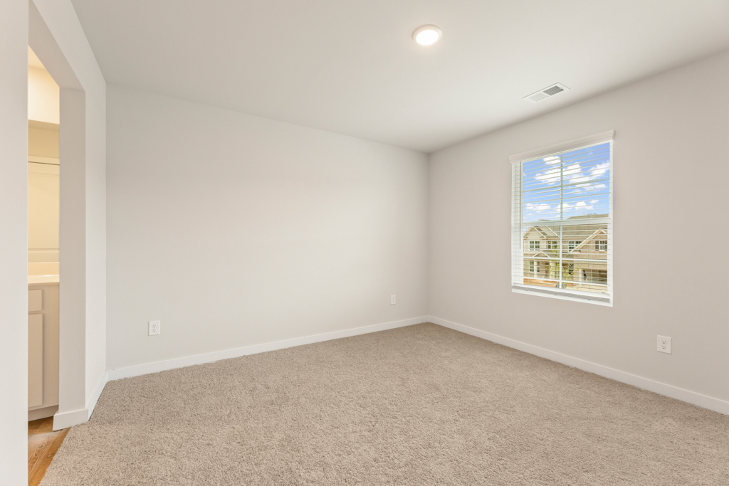 A room with a window and a carpet.