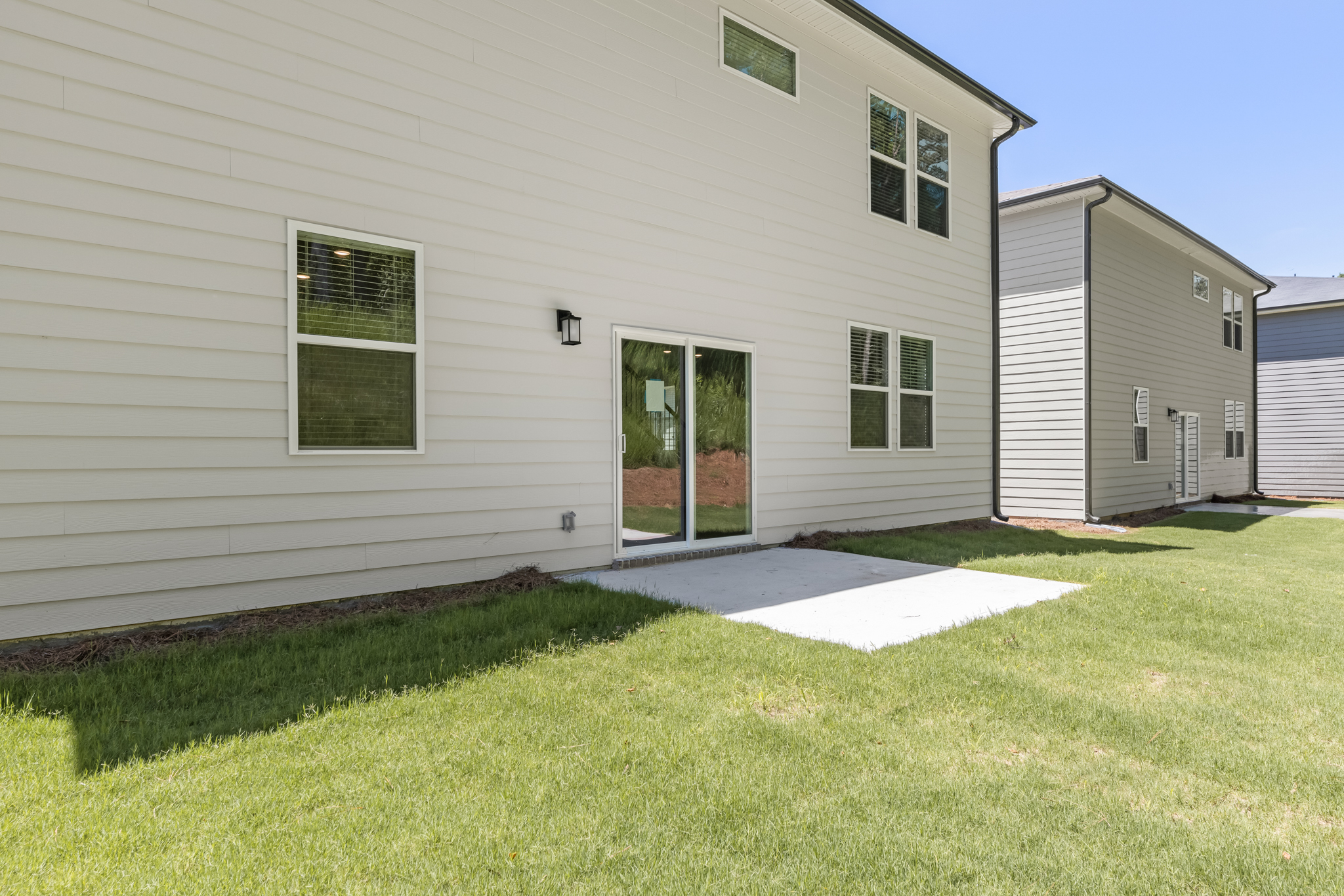 A white house with a lawn.