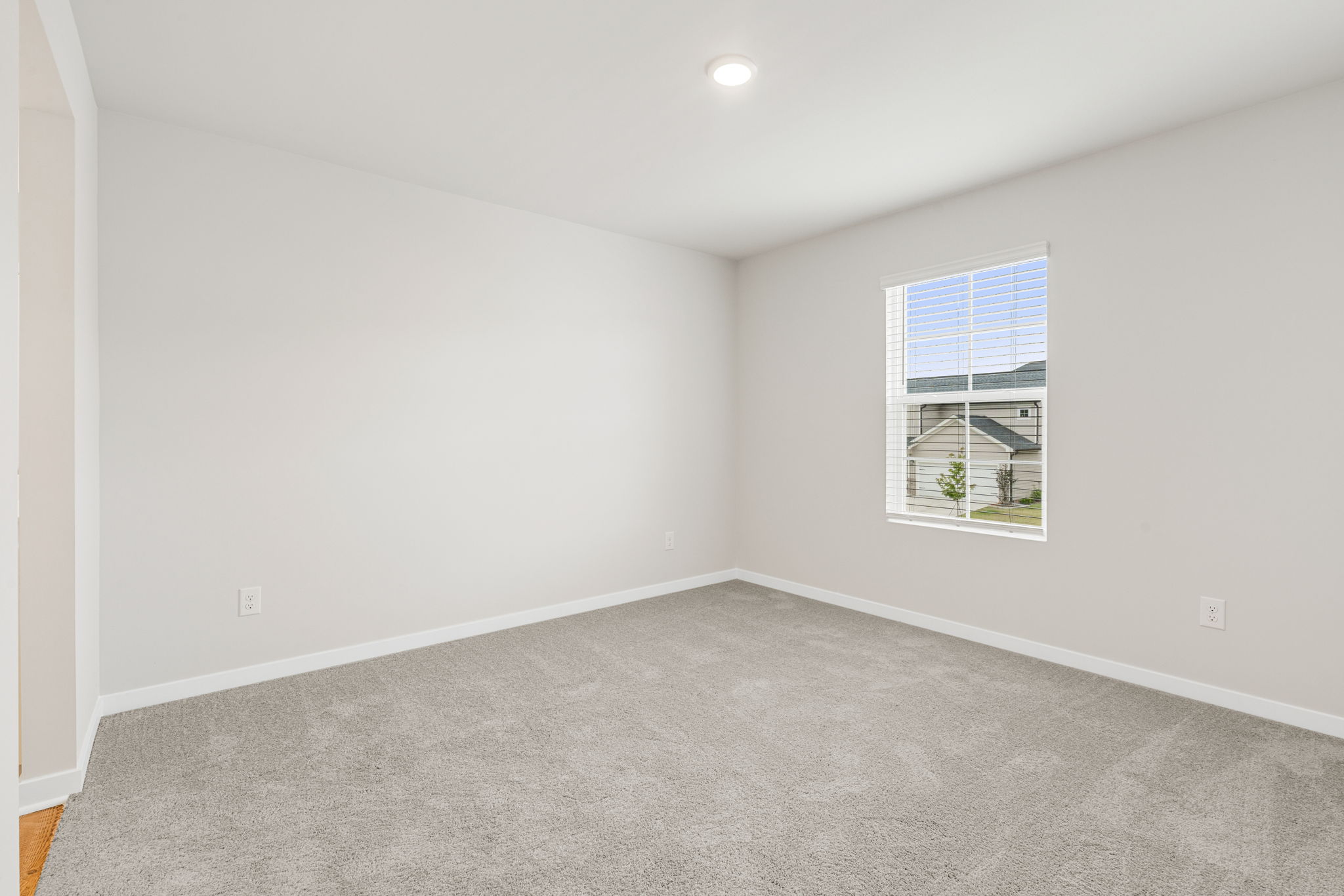 A room with a window and a carpet.