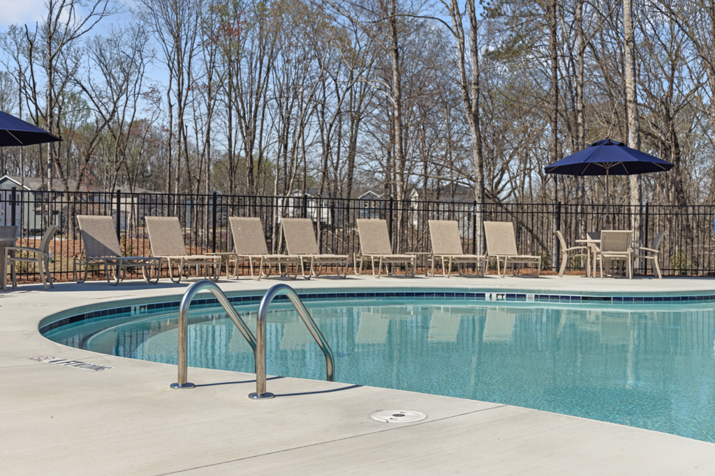 A pool with chairs around it.
