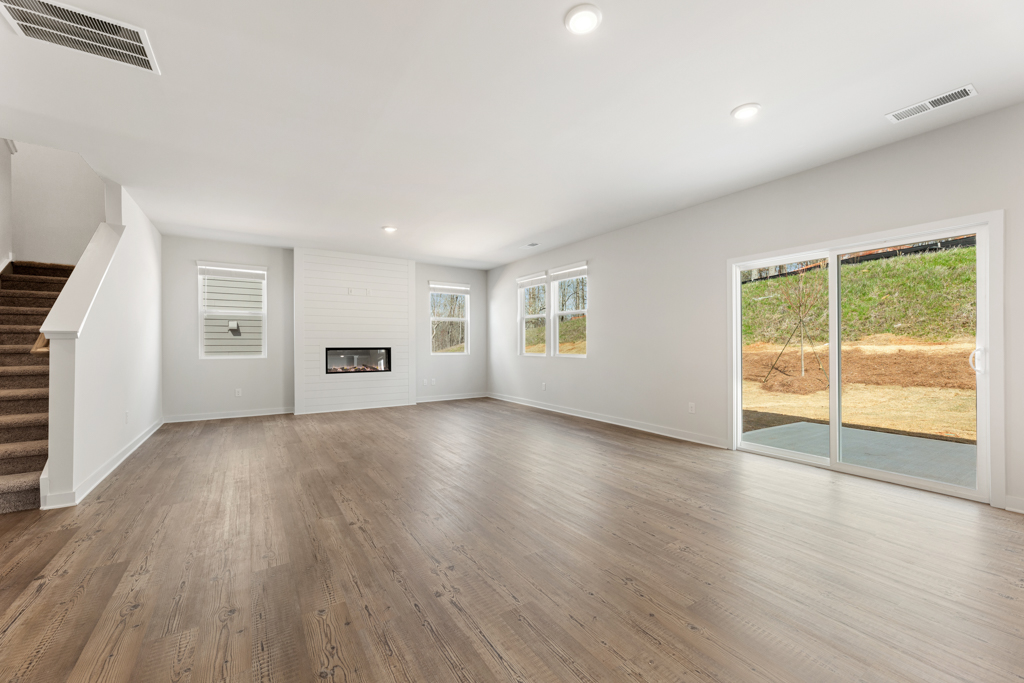 A large empty room with a wood floor and a wood floor.