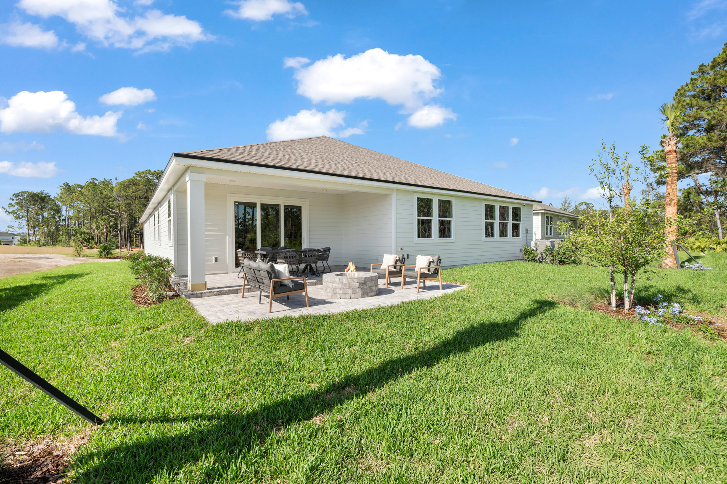 Kenai Model Home Backyard with Firepit and Covered Patio at Reserve East in Flagler Beach