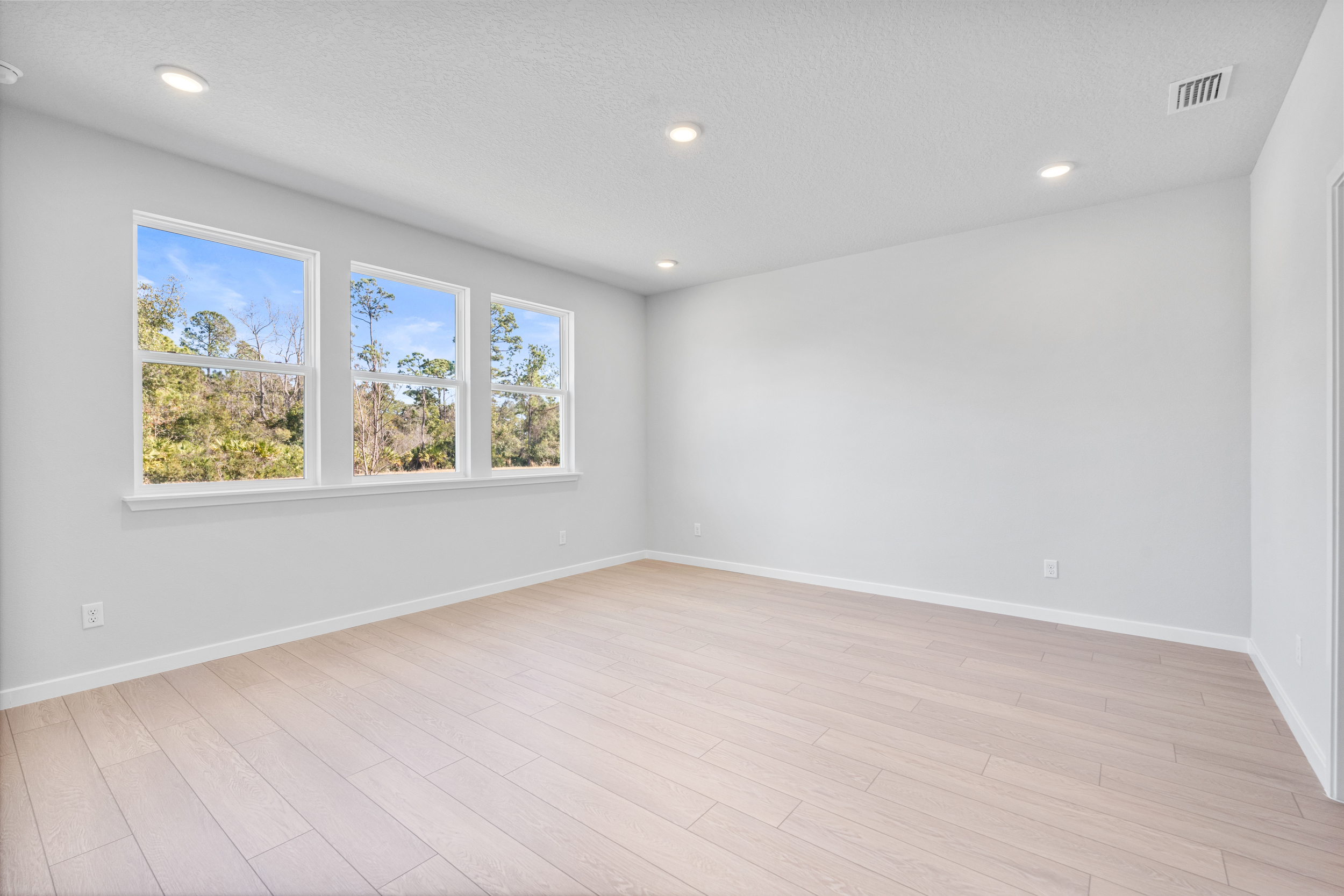 Lot 139 Primary Bedroom with LVP Floors and Three Windows at Reserve East