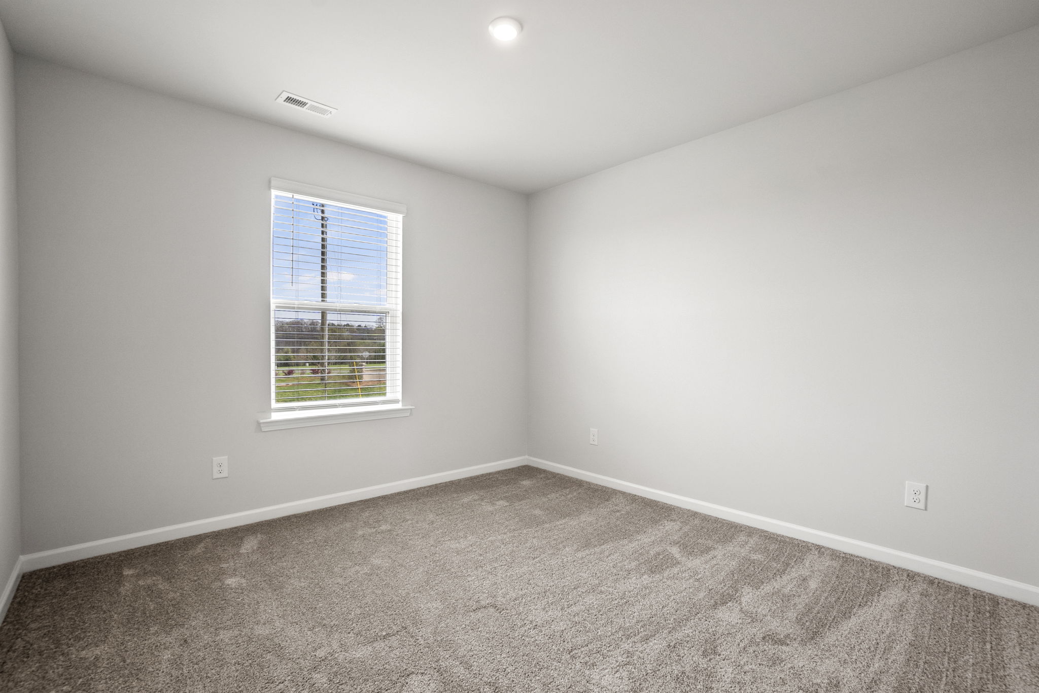 A room with a window and a carpet.