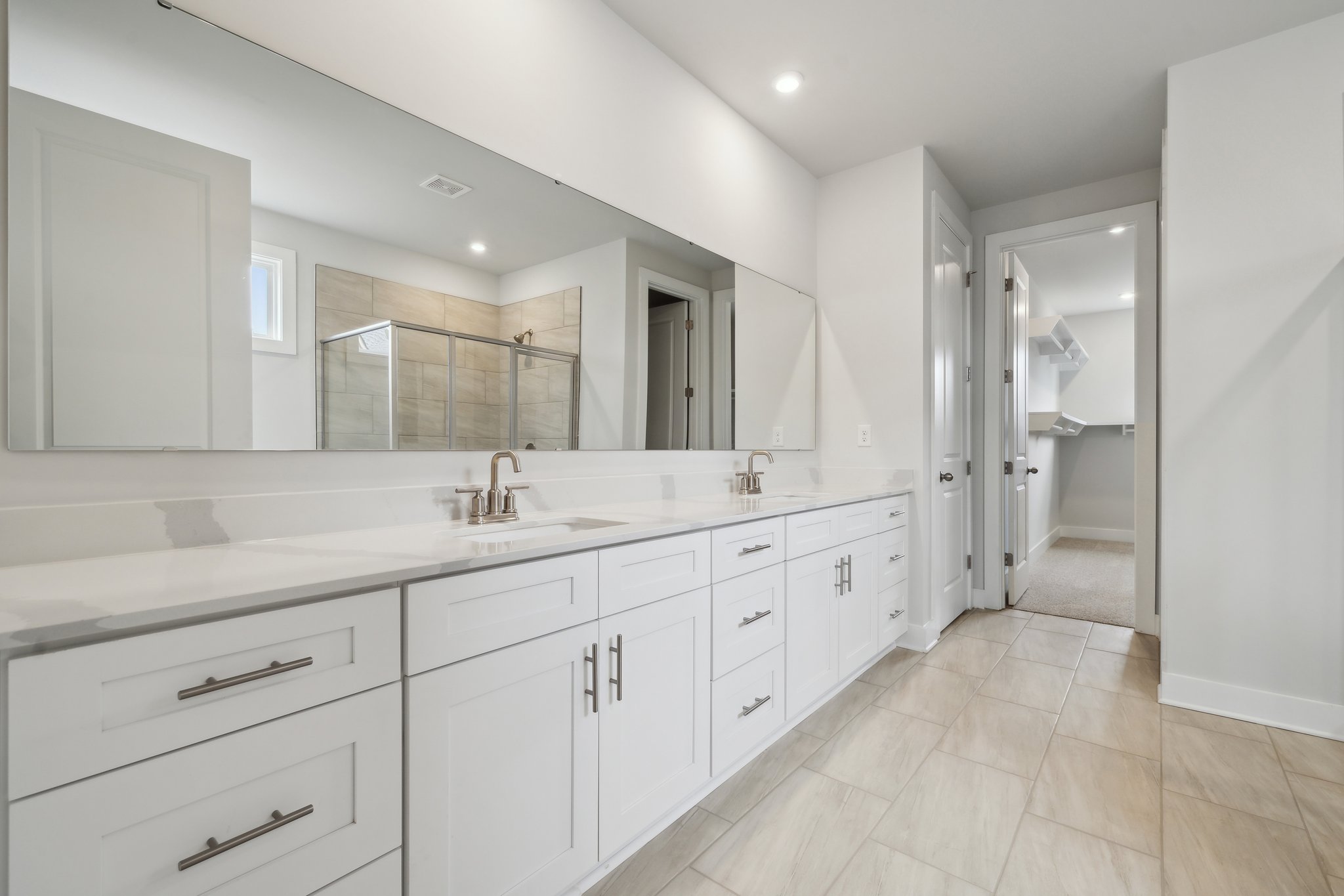 A bathroom with white cabinets.