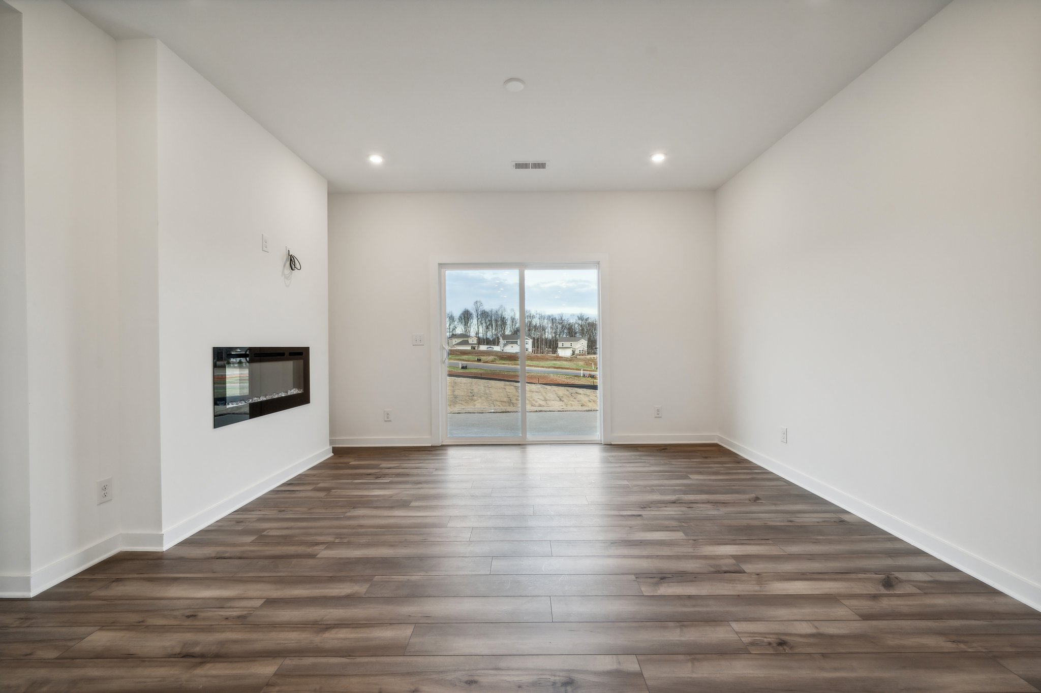 A room with a wood floor and a large window.