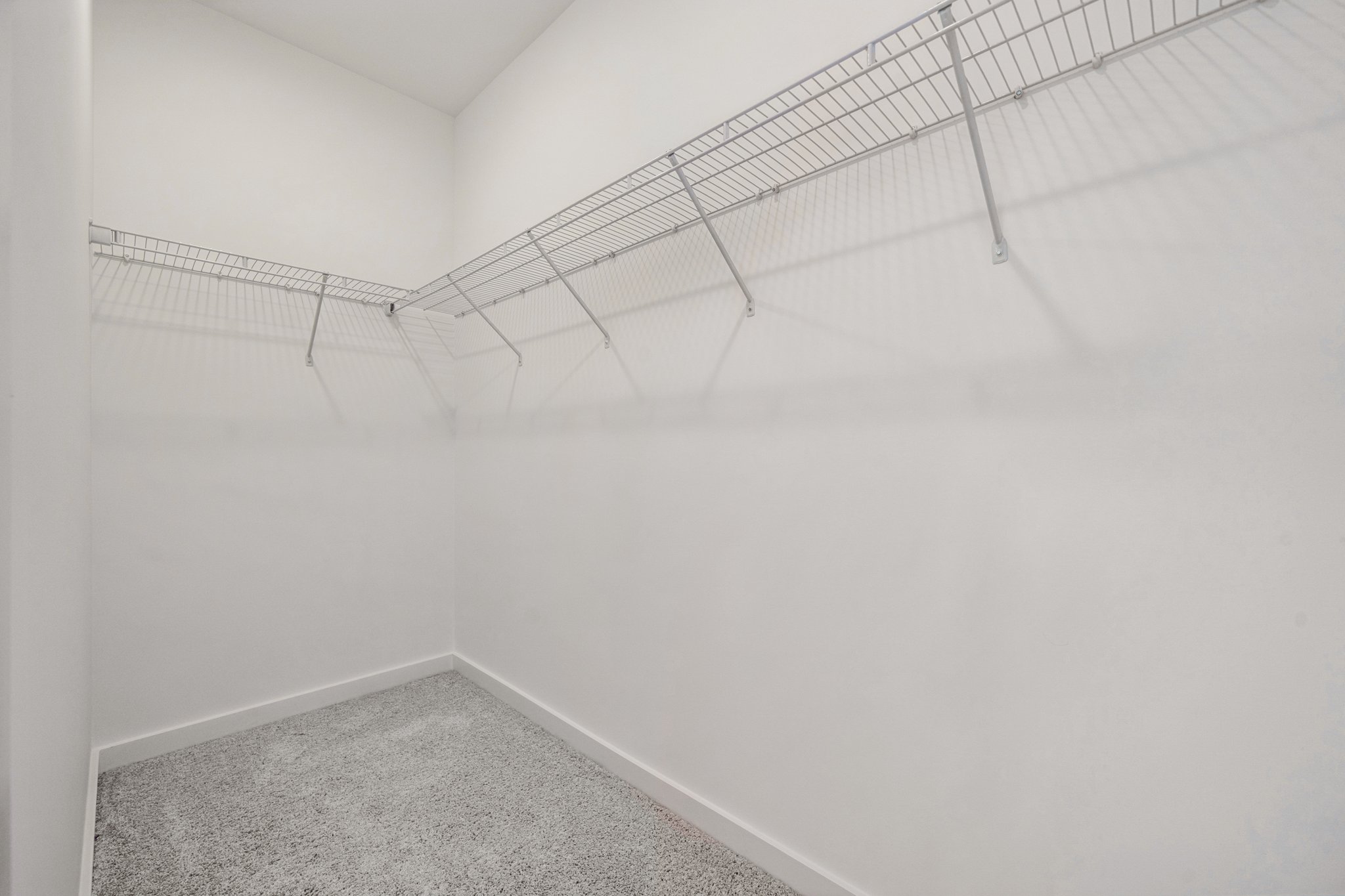 A white wall with a metal bar.