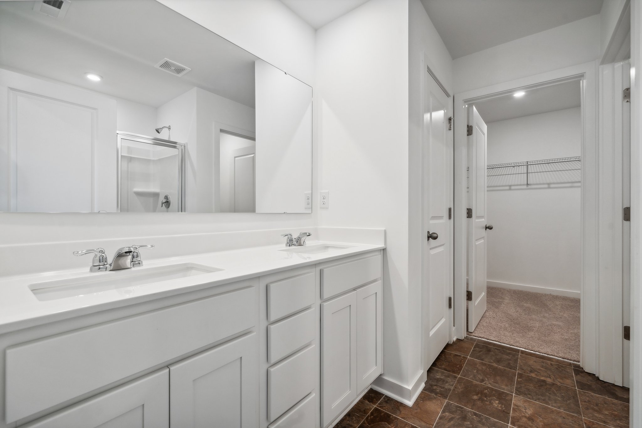 A bathroom with white cabinets.