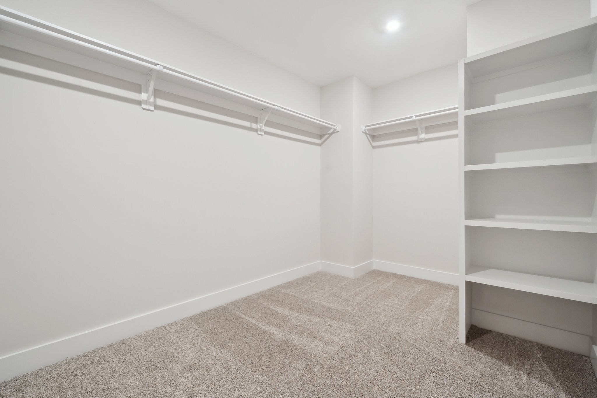 A white room with a white shelf.