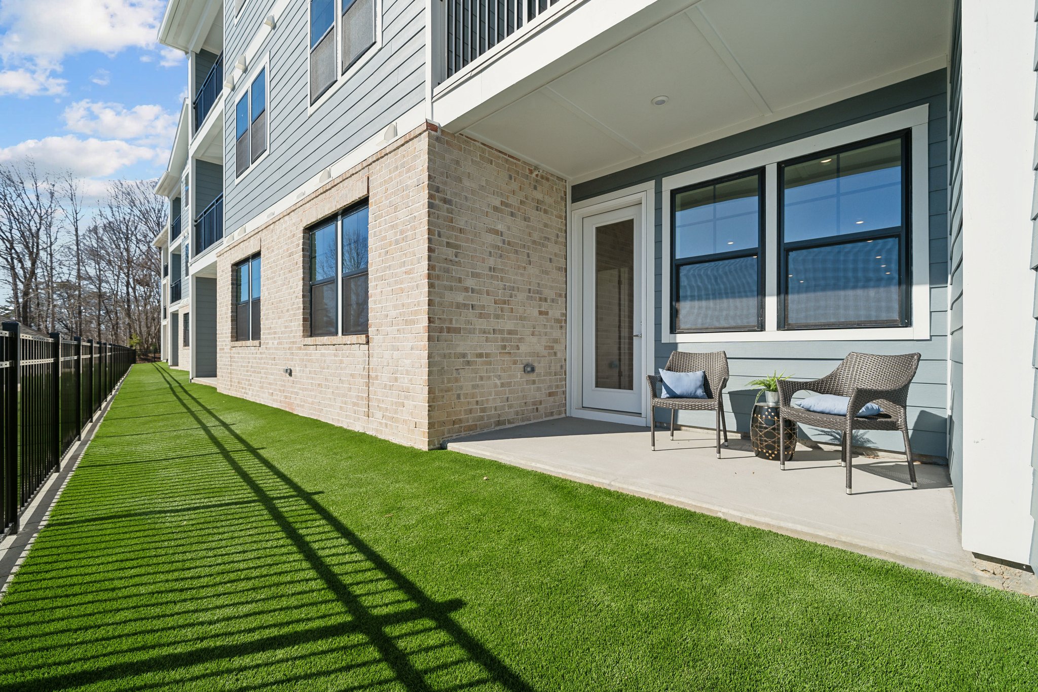 A house with a lawn and chairs.