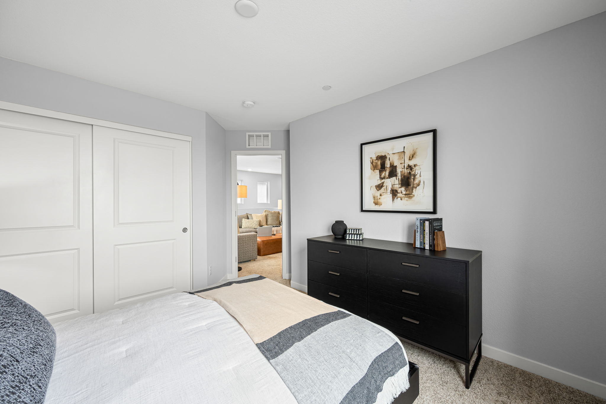 A bedroom with a bed and dresser.