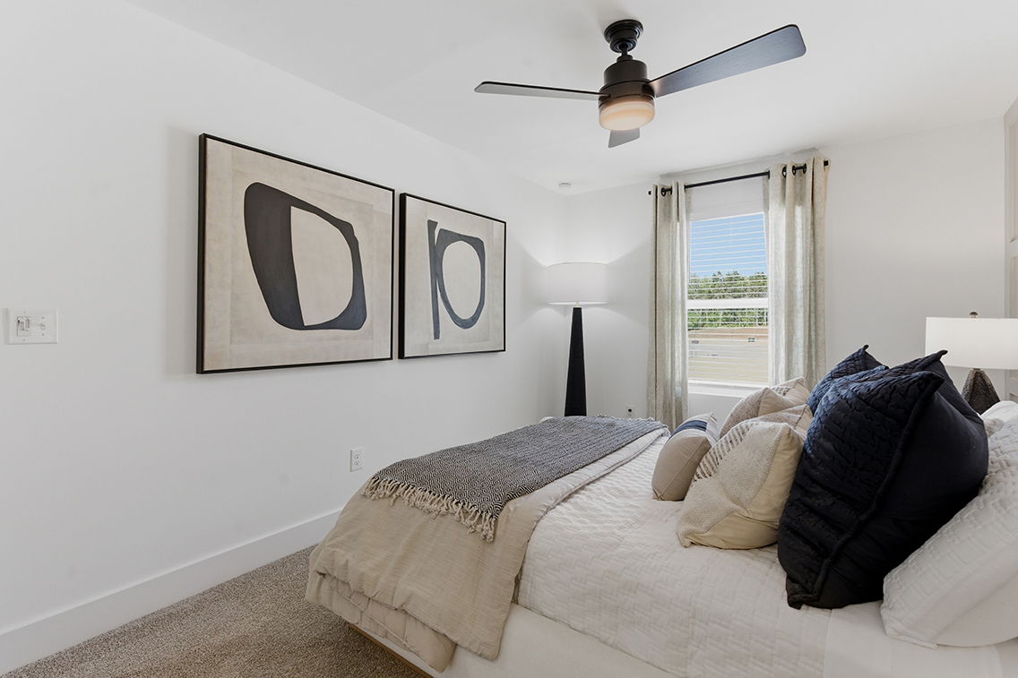 A bedroom with a bed and a lamp.