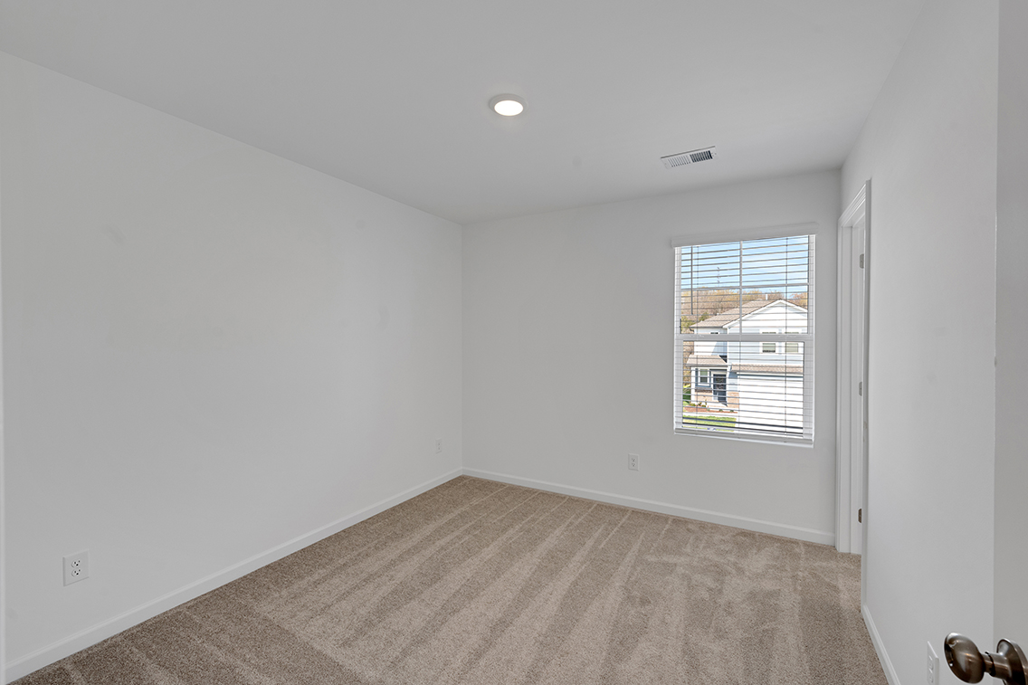 A room with a window and a rug.