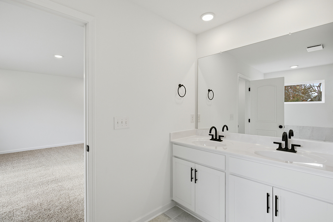 A bathroom with white cabinets.