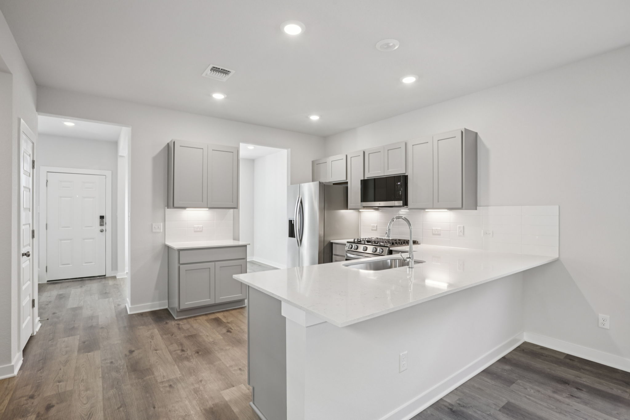 A kitchen with white cabinets.
