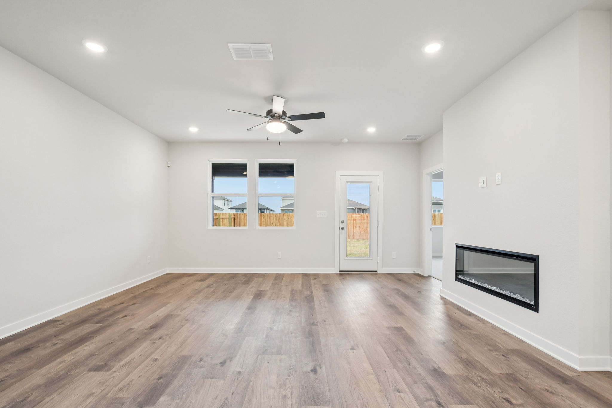 A room with a wood floor and a ceiling fan.