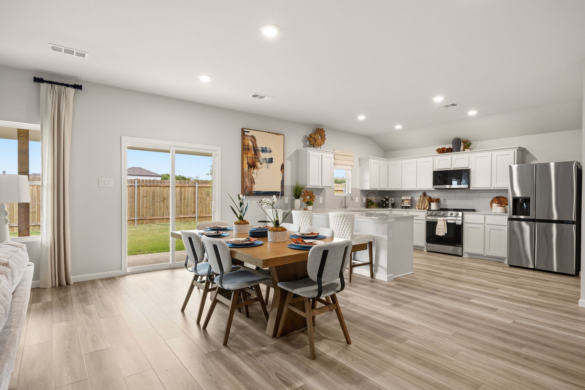 A kitchen with a dining table and chairs.