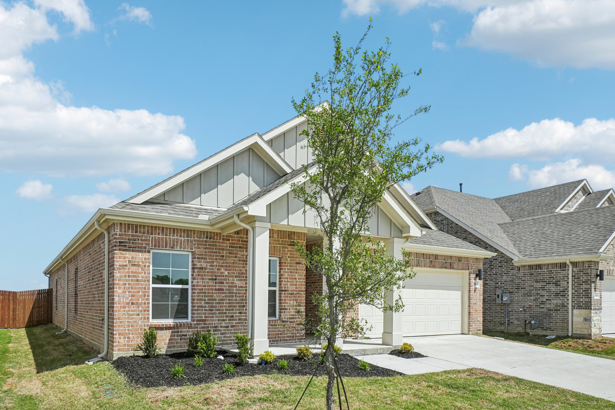 A brick house with a tree in the front.