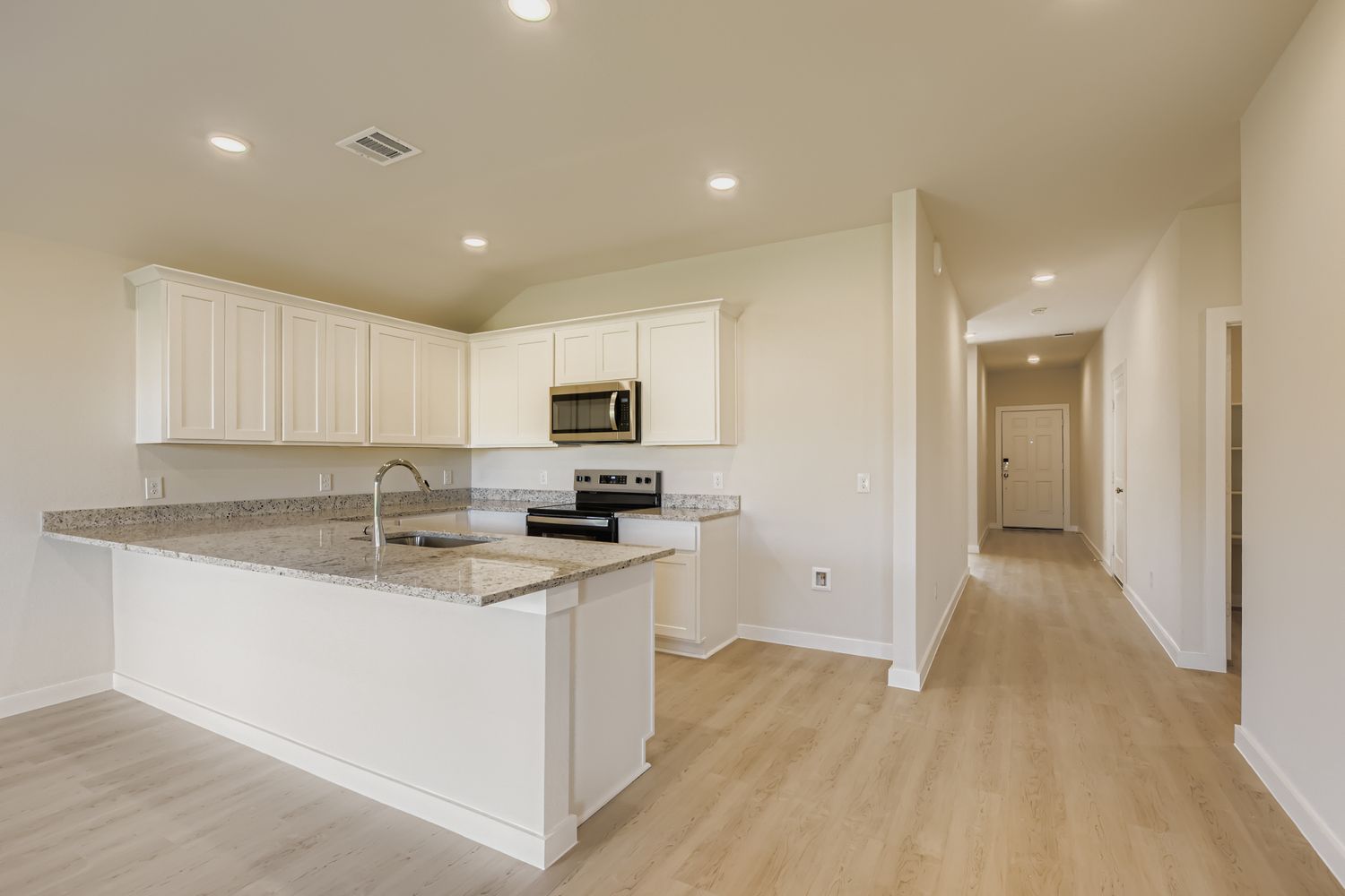 A kitchen with white cabinets.