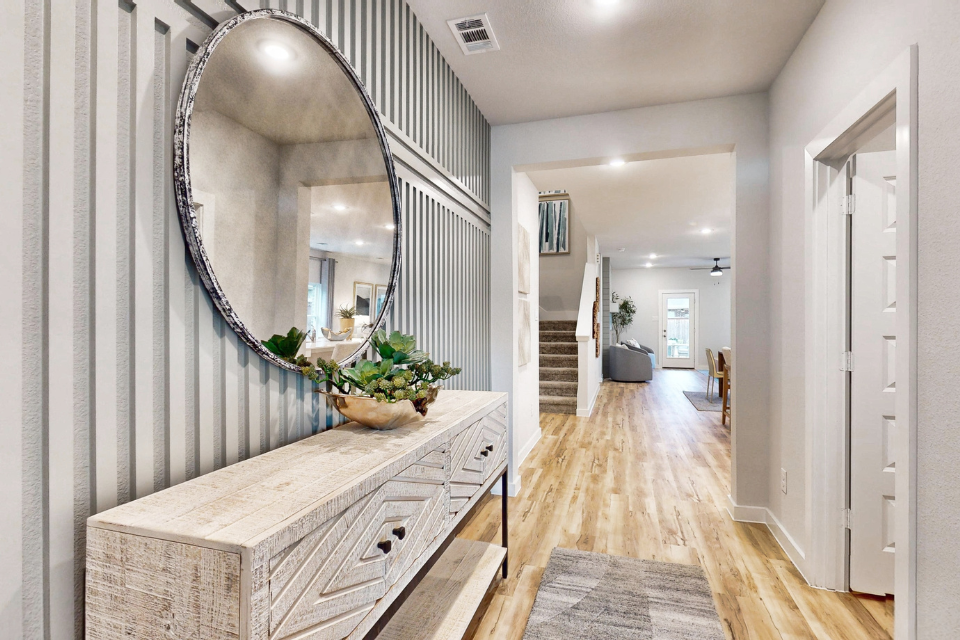 A long hallway with a round mirror.