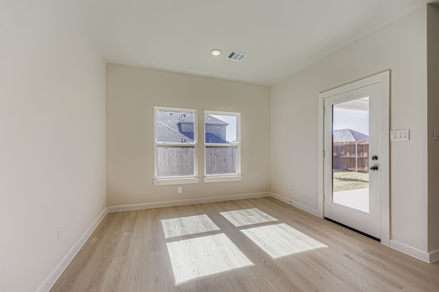 A room with a wood floor and a door with a window.